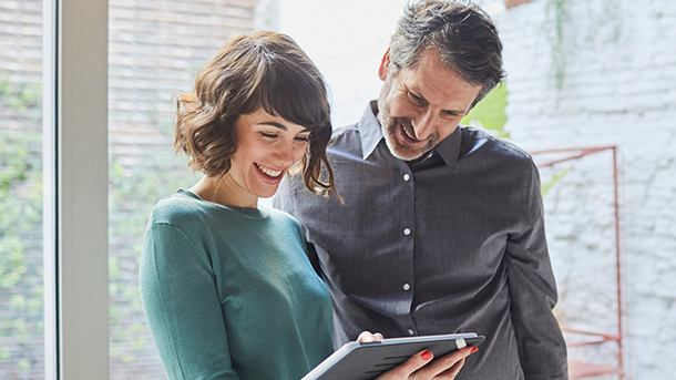 Male and female smiling with laptop